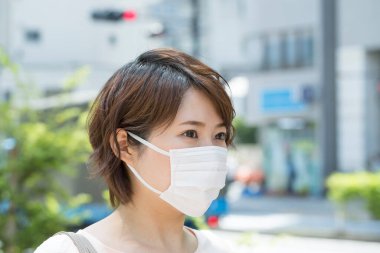 Koruyucu maskeli genç bir Japon kadının portresi.