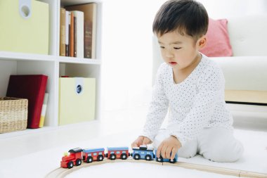 Şirin Japon çocuk evde oyuncaklarla oynuyor.