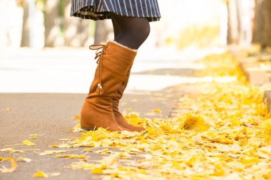 Sarı akçaağaç yapraklı kız sonbahar parkında.