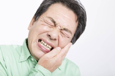 Diş ağrısı olan Asyalı bir adamın portresi. 