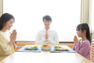 Aile yemekten önce yemek masasında dua eder.