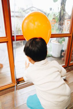 Asyalı küçük çocuk bir balonla oynuyor. 