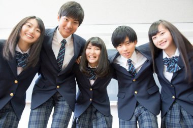 Sınıfta sarılan genç Japon öğrencilerin portresi.