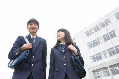 Okulda çantalı genç Japon öğrencilerin portresi.