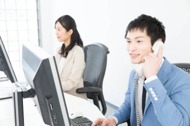 Genç Asyalı çalışanlar ofiste çalışıyor.