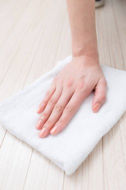 Tahta bir masanın üzerinde havlu tutan bir el.