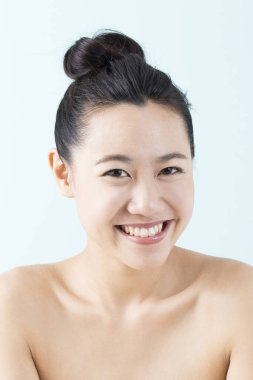 Güzel Asyalı kadın izole edilmiş arka planda gülümsüyor.