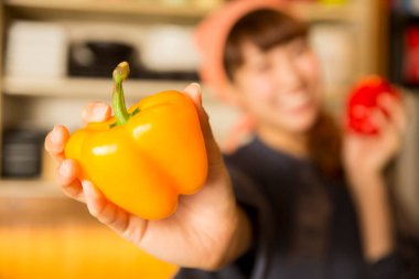 Mutfakta turuncu dolmalık biberli Asyalı kadın