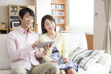 Evde dijital tablet kullanan genç çift