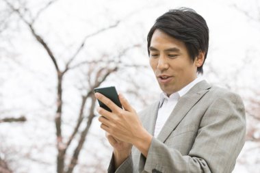 İş adamı cep telefonuyla mesaj gönderiyor