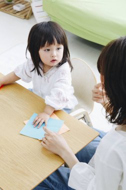 Evde annesiyle oynayan tatlı Asyalı kız.