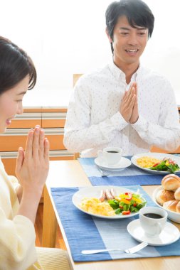 Çift kahvaltıdan önce dua ediyor.