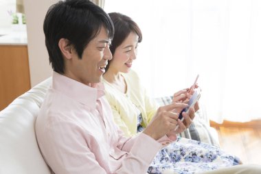 Asyalı aile evde akıllı telefonlar kullanıyor, yaşam tarzı konsepti..