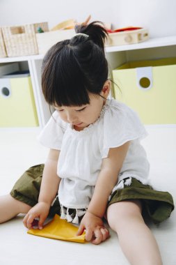 Oturma odasında oynayan küçük tatlı bir Japon kız.
