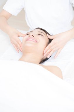 Genç bir kadın spada masaj yaptırıyor.