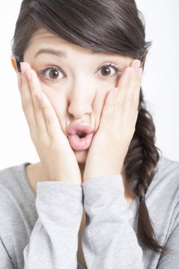 Genç Asyalı kadın şaşırdı ve şok oldu. 