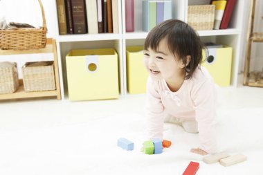 Yerde oynayan Asyalı çocuk. 