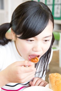 Asyalı bir kadının yemek yerken yakın plan fotoğrafı.