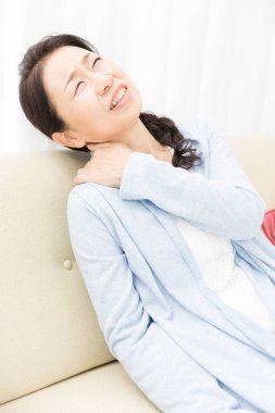 Asyalı kadının evinde boyun ağrısı var. 