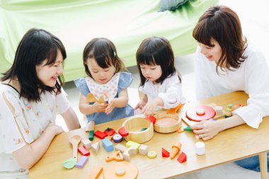 Evde annelerle oynayan tatlı Asyalı kızlar.