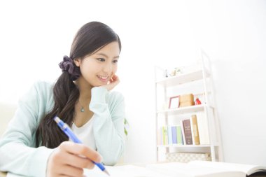 Bayan öğrenci evde okuyor. 