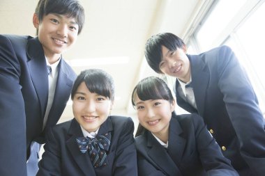 İçeride okul üniforması giyen gülümseyen öğrenciler.