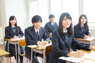 Genç Japon öğrenciler sınıfta okuyor.