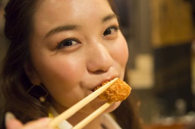 Genç kadın çubukla yemek 