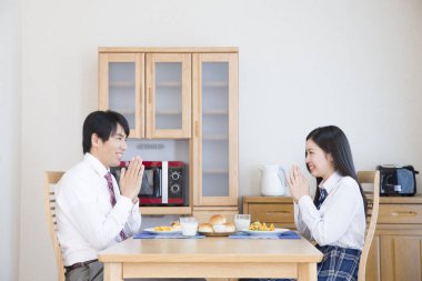 Gülümseyen baba ve kız kahvaltıyı evde yapıyorlar.