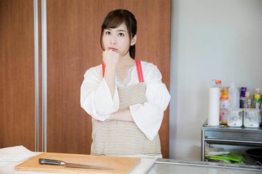 Mutfakta bıçaklı çekici Asyalı kadın portresi.