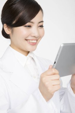 Tablet bilgisayarı olan Asyalı kadın doktor beyaz arka planda izole edildi 