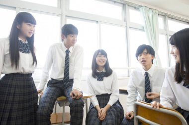 Parlak sınıfın içinde gülümseyen öğrenciler.