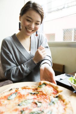 Evde pizzası olan genç bir kadın.