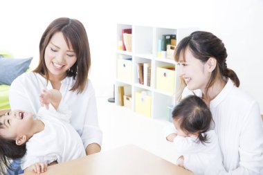 Küçük çocuklarla gülümseyen iki kadın.