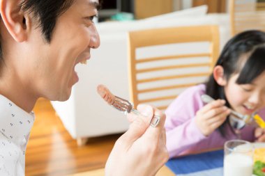 Baba ve kızı kahvaltıda eğleniyor.