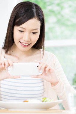 Yemek fotoğrafı çeken genç bir kadın. 