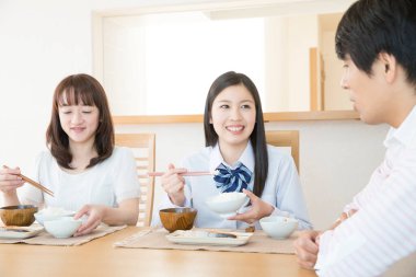 İnsanlar yemek masasında yemek yiyor.