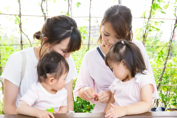 Açık kafede bebekleri olan mutlu Asyalı bir anne. 