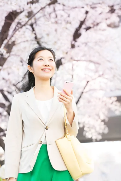 Красива Усміхнена Молода Азіатка Сумкою Допомогою Смартфона Прогулянки Весняному Парку — стокове фото