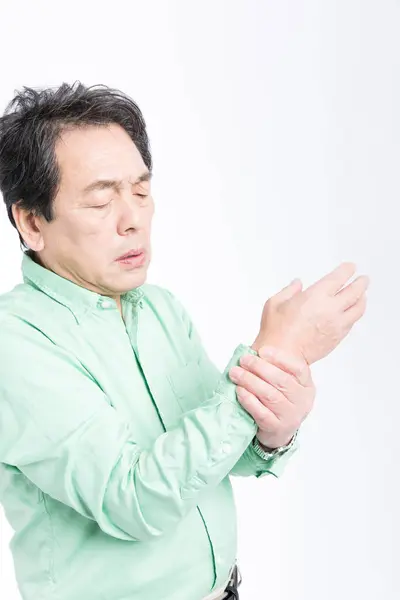 白い背景で孤立した手の痛みに苦しんでいるアジアのシニア男性 — ストック写真