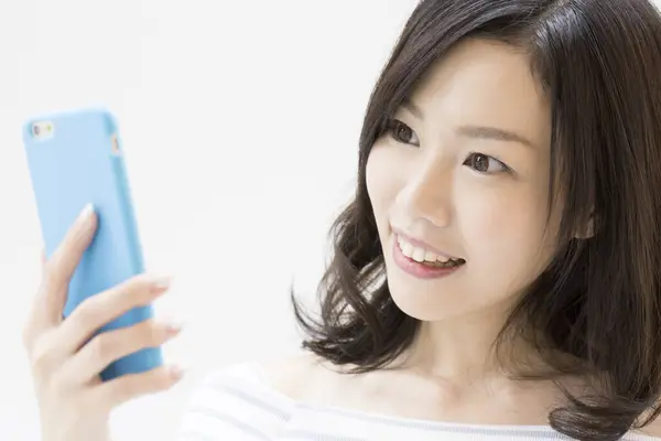 Studio Zdjęcie Pięknej Japońskiej Kobiety Pomocą Smartfona Białym Tle — Zdjęcie stockowe