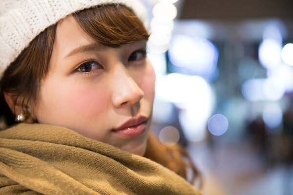 азиатская женщина в теплом шарфе и шляпе на улице 