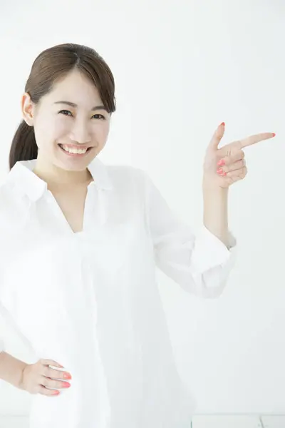 Piękna Japonka Pokazuje Coś Palcem Wskazującym Białym Tle — Zdjęcie stockowe