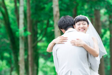 Parkta poz veren Asyalı gelin ve damat 