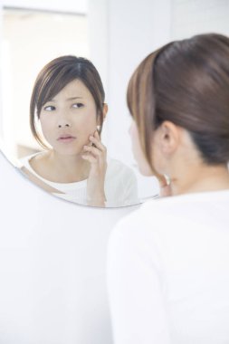 Genç güzel kız banyodaki aynaya bakıyor..