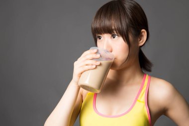 Asyalı kadın milkshake içiyor. 