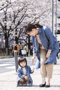 Annesiyle yürüyen sevimli Japon çocuğunun portresi.