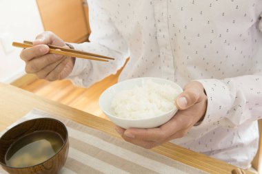 Kadının yemek çubuğuyla pirinç yediği yakın çekim.