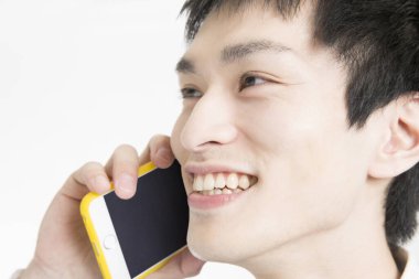 Beyaz arka planda izole edilmiş cep telefonu kullanan genç adam.