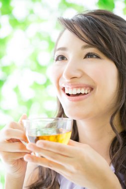 Bahçede çay içen genç bir kadın